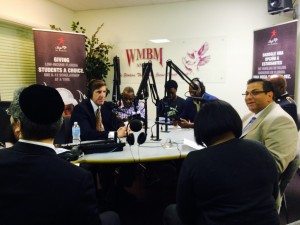 Supporters of tax credit scholarships gather around the mics in WMBM studios.